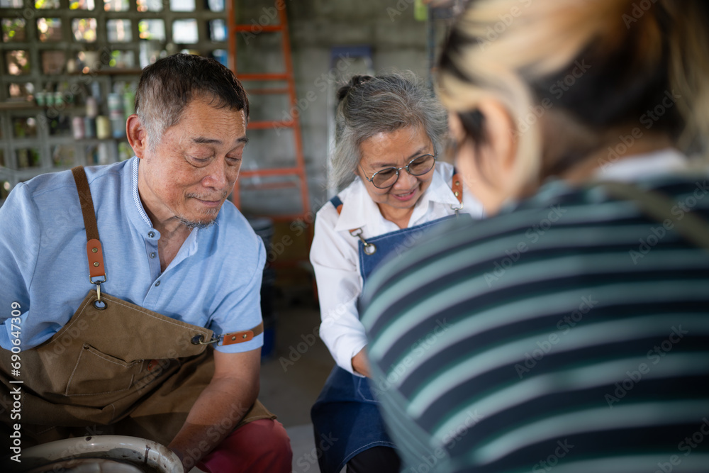 Fototapeta premium Portrait of a senior Asian couple doing activities together in the pottery workshop.