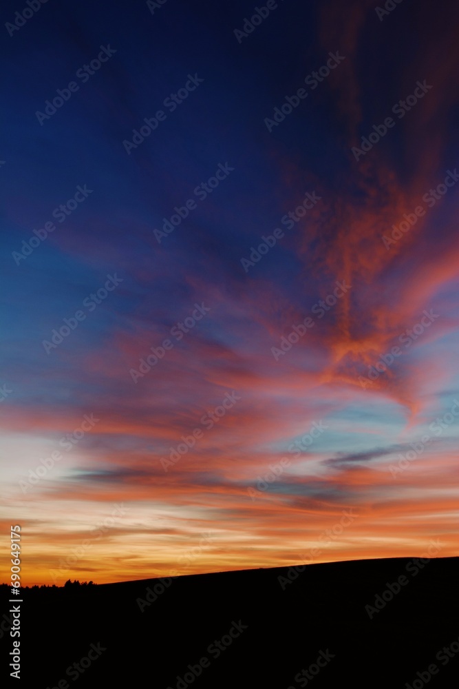 Sunset with clouds being painted in bright red color 