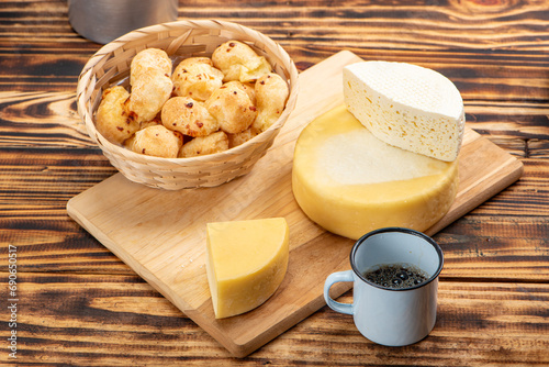 Fototapeta Naklejka Na Ścianę i Meble -  Cheese bread and cheese, a table with cheese bread and pieces of cheese and a cup of coffee on a rustic table, selective focus.