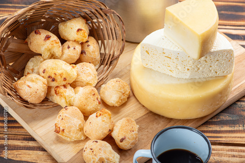 Cheese bread and cheese, a table with cheese bread and pieces of cheese and a cup of coffee on a rustic table, selective focus.