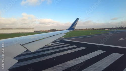 Gneric airplane wing view shot seat perspective lining up line up onto runway preparing for take off departure background hangars photo