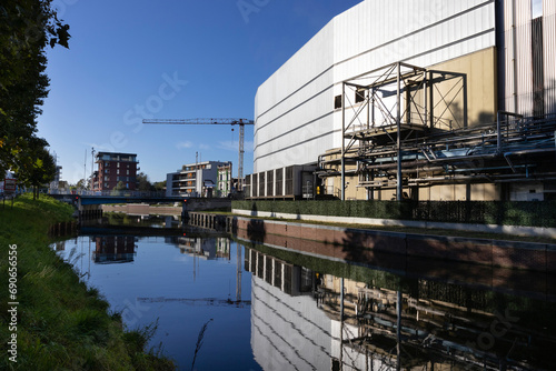 View of the river Dender and surrounding industrial landscape as it  flows through Aalst in East Flanders, Belgium. View towards the 'Zeeberg' Bridge on a sunny morning, with copy space above. photo