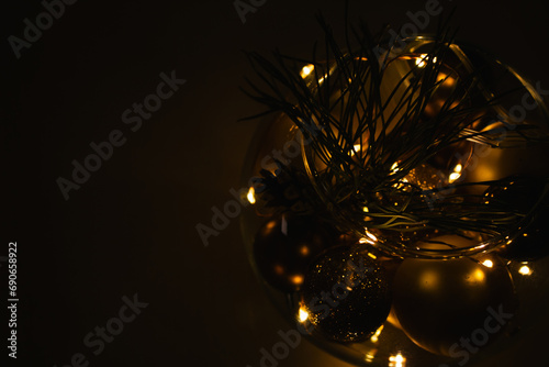 Shiny golden balls with garland in glass jar. Christmas background. Christmas garland lights in the night. Illuminated New Year card. Winter holidays decoration. Magical Christmas background. 