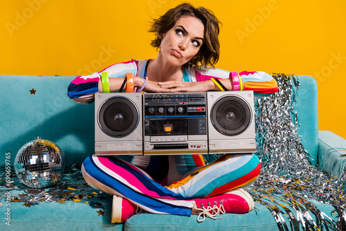Photo of serious girl hold disc ball boombox sitting couch thinking planning christmas event isolated shine color background
