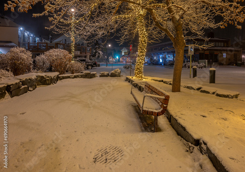 Night view of Christmas decorated trees and a bench on Civic Plaza in Canmore, Alberta, Canada