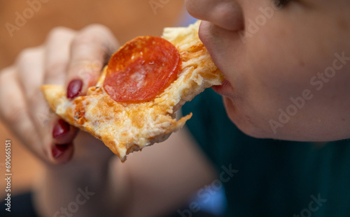 Closeup of woman eating slice of pizza