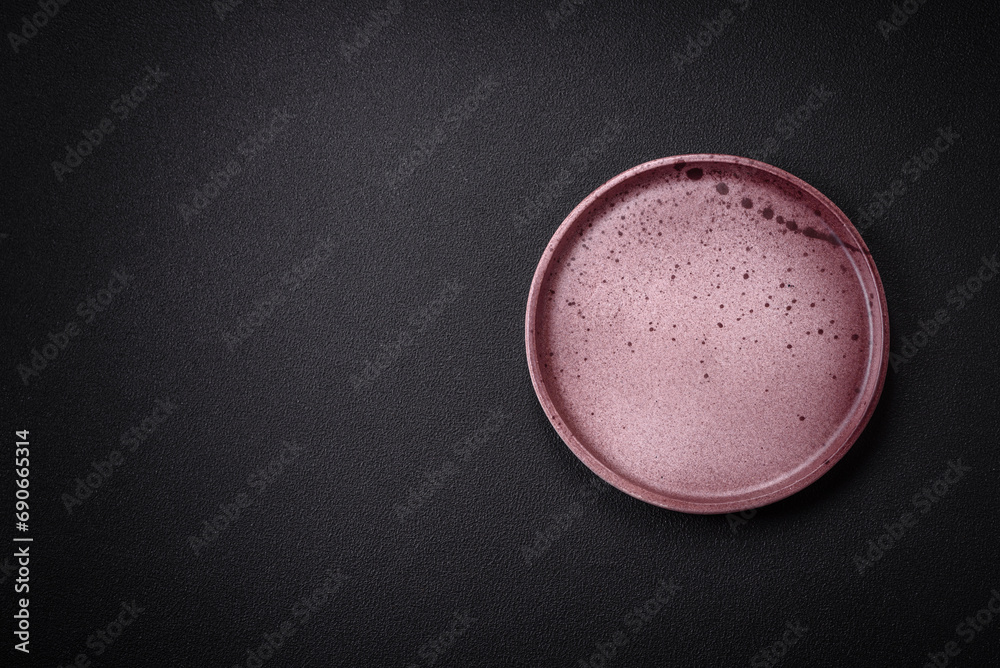 Bumpy empty ceramic plate on a textured concrete background Bumpy empty ceramic plate on a textured concrete background