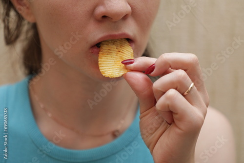 Closeup of woman eating potato chip