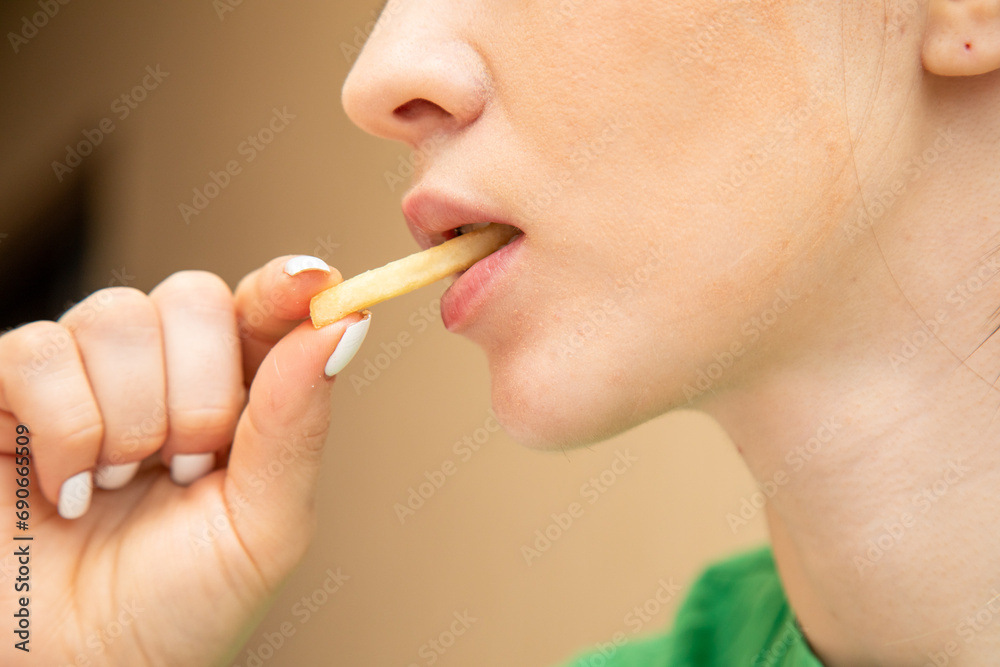 Closeup of woman eating fries Closeup of woman eating fries