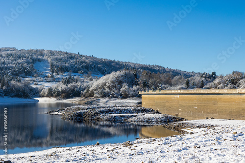 Barrage de Lavalette entourée d’une forêt de sapins, dans les Gorges du Lignon, sous les premières neiges de l’hiver photo