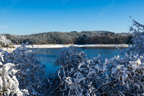 Lac de Lavalette entourée d’une forêt de sapins, dans les Gorges du Lignon, sous les premières neiges de l’hiver photo