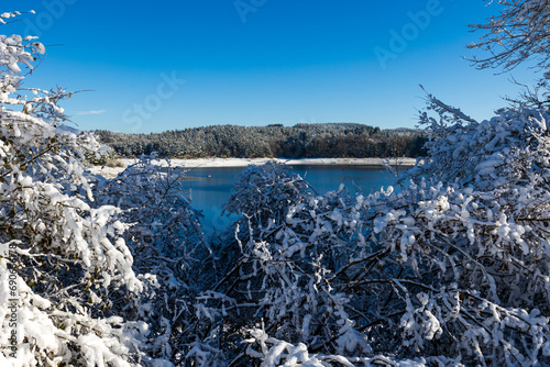 Lac de Lavalette entourée d’une forêt de sapins, dans les Gorges du Lignon, sous les premières neiges de l’hiver photo