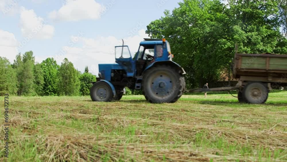 Hand Held Wide Shot of Blue Retro Tractor with Wooden Cargo Trailer Carrying Planks Hand Held Wide Shot of Blue Retro Tractor with Wooden Cargo Trailer Carrying Planks