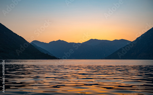 Sunset mountain and sea landscape. Kotor bay  Montenegro.  Silhouette of mountains near Adriatic sea at sunset orange sky. Evening view.