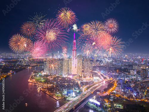 Celebration. Aerial view of Landmark 81 skyscraper with fireworks light up sky over business district in Ho Chi Minh City, Vietnam. Saigon bridge in night view.