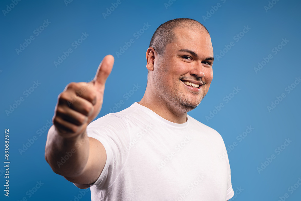man giving a thumbs up with his right hand, smiling man giving a thumbs up with his right hand, smiling