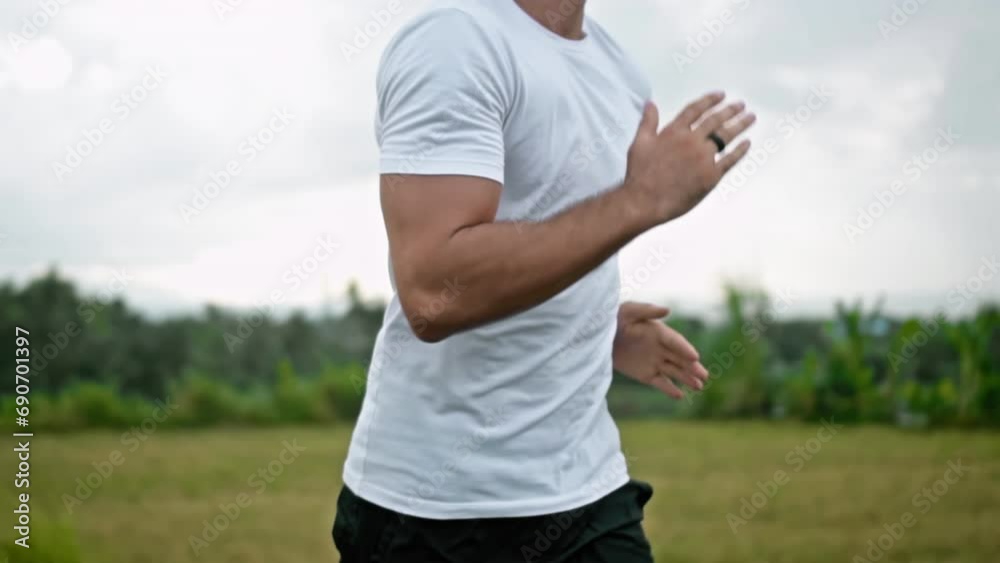 Man runs on the street with rice fields in background in slow motion Man runs on the street with rice fields in background in slow motion