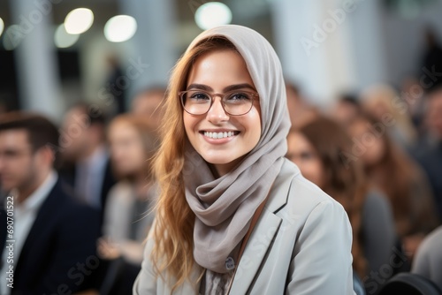 A woman in a headscarf smiles at the camera