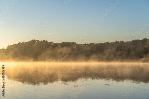 Fototapeta Naklejka Na Ścianę i Meble -  Dawn scenery in fall at a foggy lake near Waren, Muritz, Germany