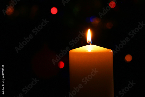 Christmas candle on the background of a beautiful Christmas tree.