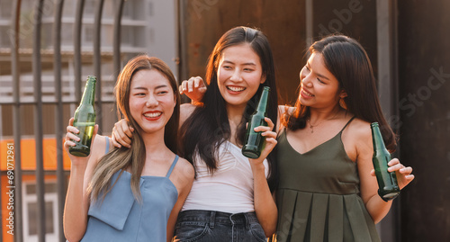 Photography Group of asian woman teenager friends cheering and toast with beer bottle to celebrating at dinner party in summertime