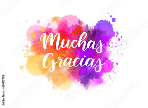 Muchas gracias - Thank you very much in Spanish. Handwritten modern calligraphy lettering text on abstract watercolor paint splash background.