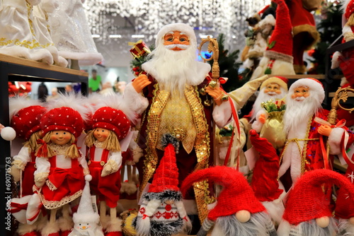 Santa Clause and Christmas dolls near Christmas tree, on store window. Beautiful favorite toys for New Year. Christmas winter shop shopping