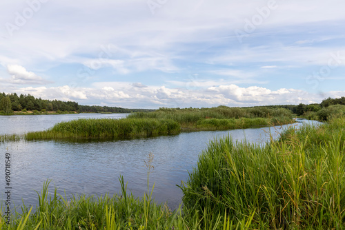 water with waves in the river in summer with green grass