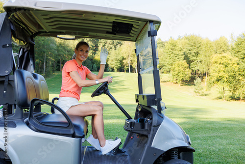 Blonde Woman Maneuvering Golf Cart On Course