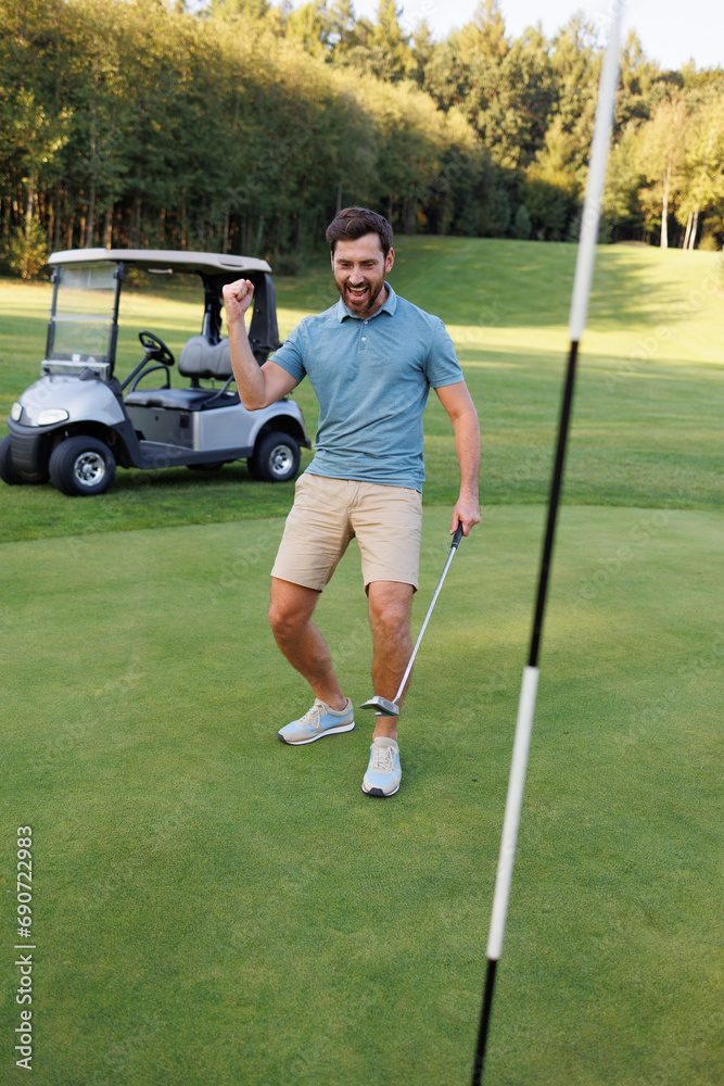 Obraz premium Golfer by the Final Hole with Golf Cart and Club