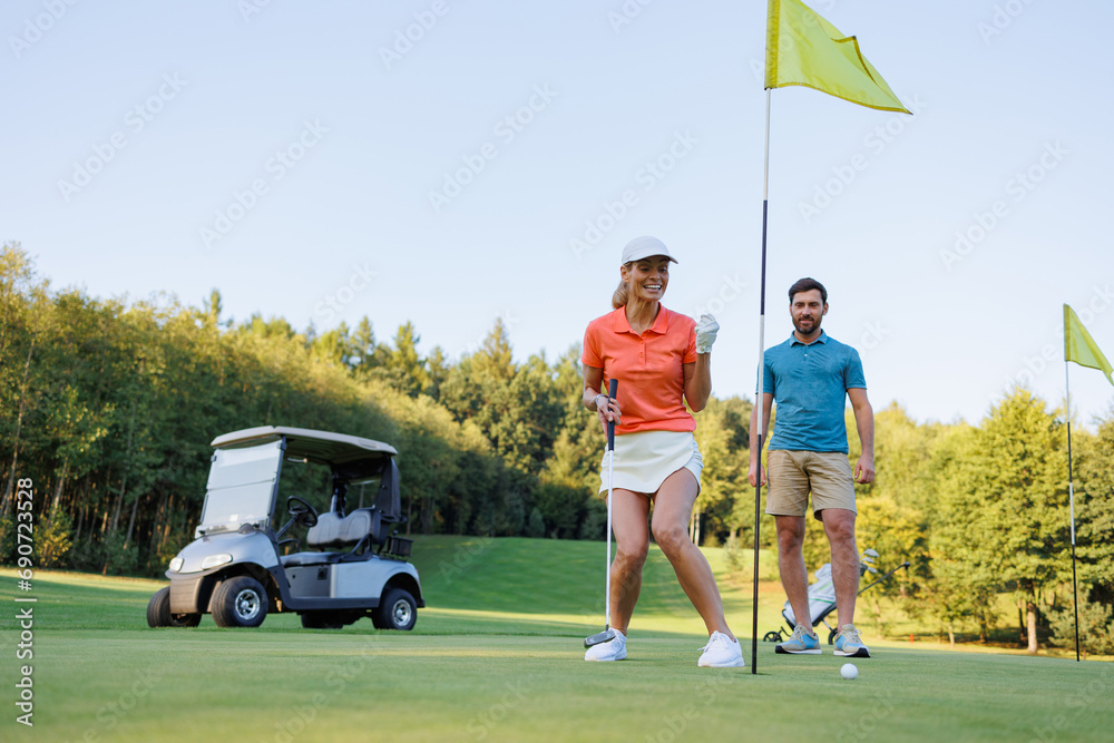 Obraz premium Celebrating Victory: Couple at Golf's Last Hole