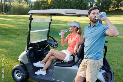Refreshing Pause: Couple Quenching Thirst on Golf Cart