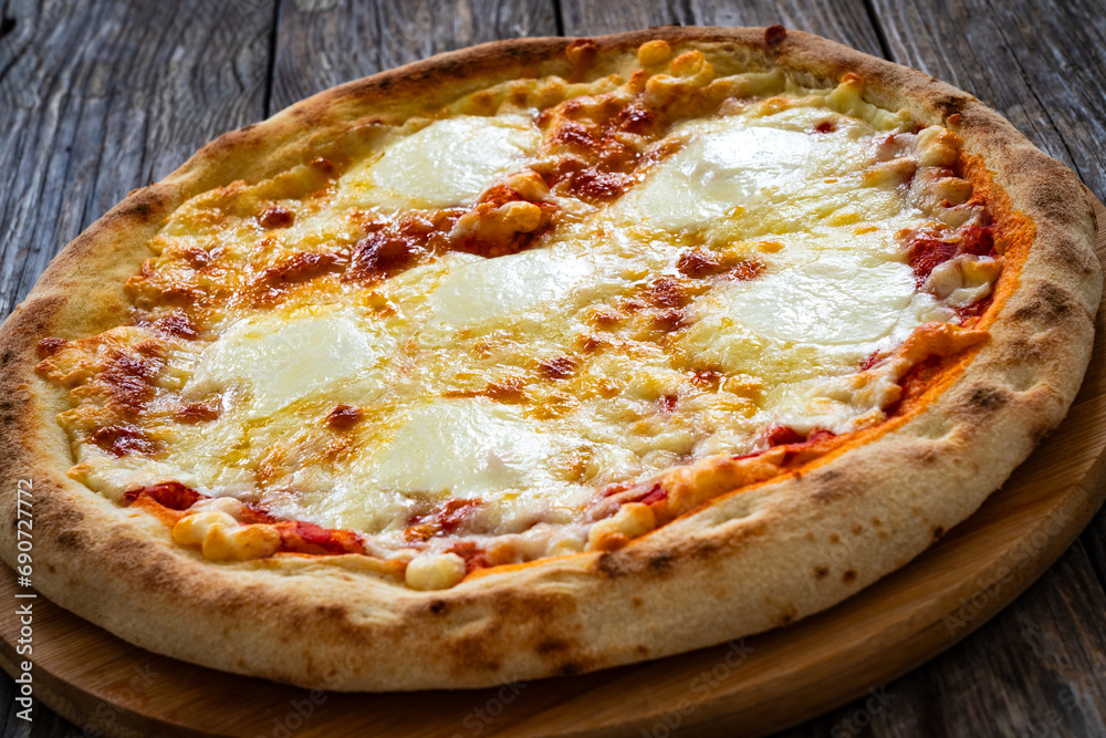 Margherita Pizza with tomato sauce and mozzarella cheese on wooden background
Margherita Pizza with tomato sauce and mozzarella cheese on wooden background