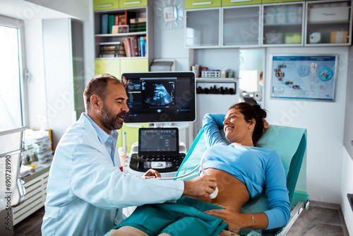 Expectant Mother Having Ultrasound with Doctor in Clinic photo