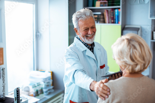Smiling doctor comforting patient at hospital photo