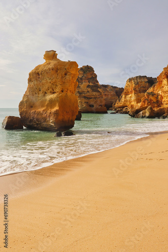 Rocks in the water on a sandy beach in southern Portugal on a winter day.
