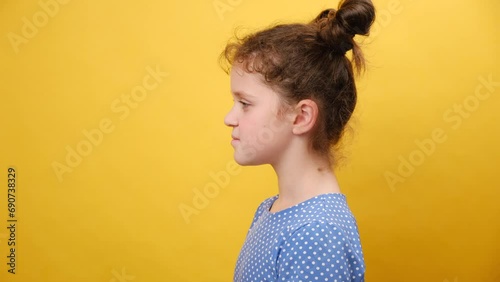 Profile side view of happy little girl kid do deep breath enjoy fresh air or dreaming fill with energy feeling healthy good concept, posing isolated over yellow studio background with copy space photo
