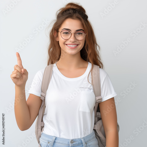 Portrait of smiling female student in eyeglasses pointing finger up