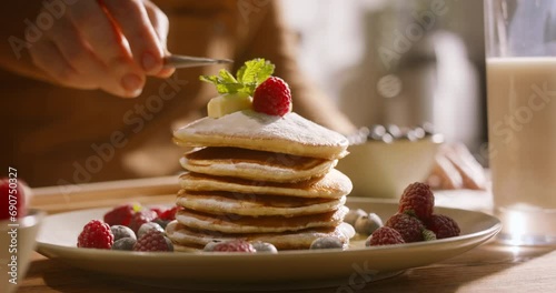 Unknown chief decorates pancakes with sprig of mint. Advertising cinematic. Excess sugar can contribute to diabetes. Comfort satisfaction of home cooking individualized approach to each client's needs photo