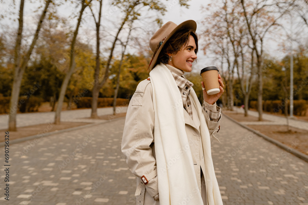 Fototapeta premium pretty smiling woman walking in park in autumn clothes
