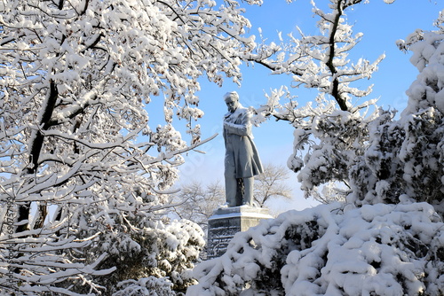 Winter in Ukraine. Monument to famous Ukrainian poet Shevchenko Taras among landscape. Trees covered with snow, winter weather. Dnipro city
