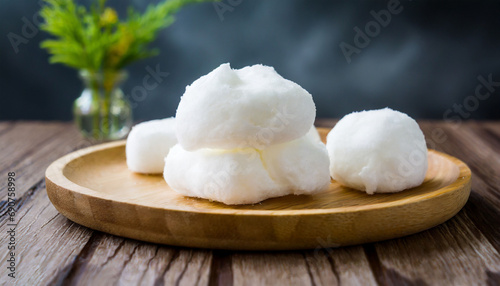 Tasty white cotton candy in a bowl on wooden table