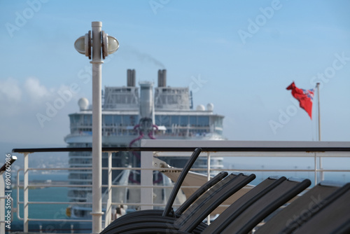 Sonnenliegen auf Luxus Kreuzfahrtschiff - Sun loungers and deck chairs on luxury oceanliner, cruiseship or cruise ship liner on outdoor deck with other vessel