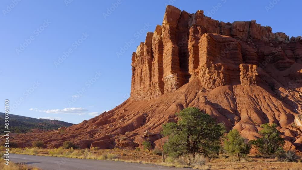 Establishing shot of mountains with red rocks background in Slickrock Divide, Capital Reef National Park, Utah, North America. Day time on October 2023. Still camera view. ProRes 422 HQ. Establishing shot of mountains with red rocks background in Slickrock Divide, Capital Reef National Park, Utah, North America. Day time on October 2023. Still camera view. ProRes 422 HQ.
