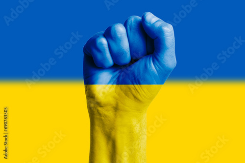 Man hand fist of UKRAINE flag painted. Close-up.