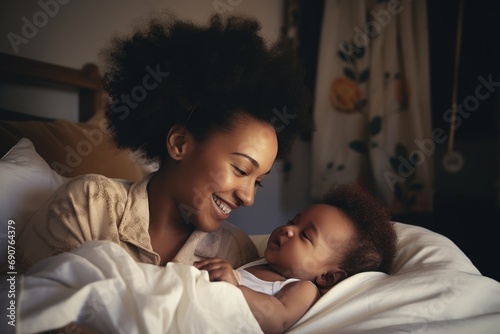 Happy mother and newborn baby embracing in bed