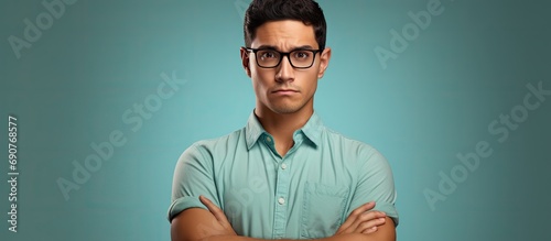 Young hispanic man wearing casual clothes and glasses skeptic and nervous disapproving expression on face with crossed arms negative person. Copyspace image. Header for website template