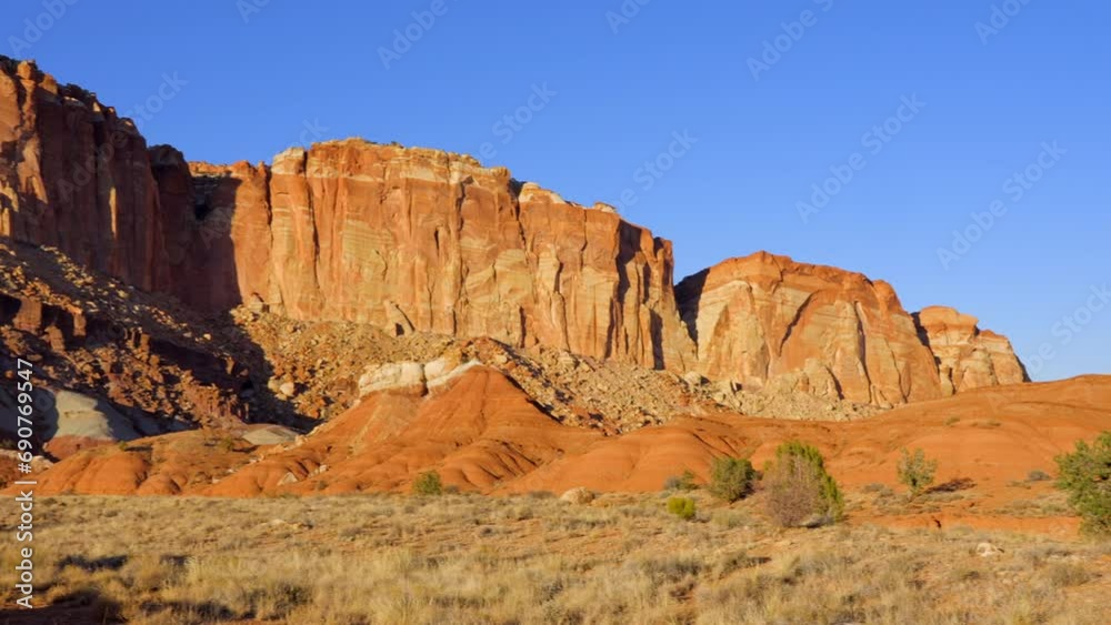 Establishing shot of mountains with red rocks background in Slickrock Divide, Capital Reef National Park, Utah, North America. Day time on October 2023. Still camera view. ProRes 422 HQ.