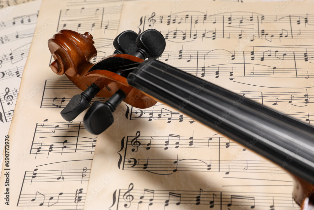 Naklejka premium Classic violin on music sheets, closeup view