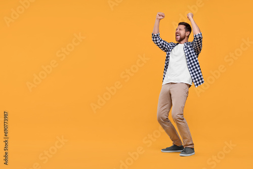 Emotional sports fan celebrating on yellow background. Space for text